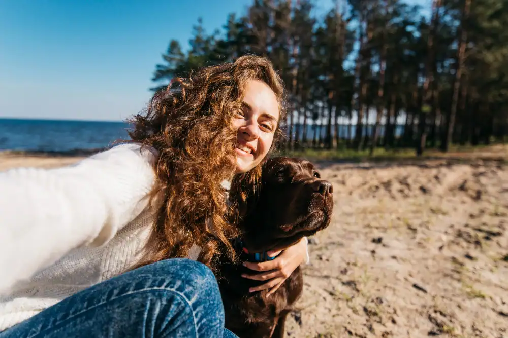Frau mit Hund am Strand