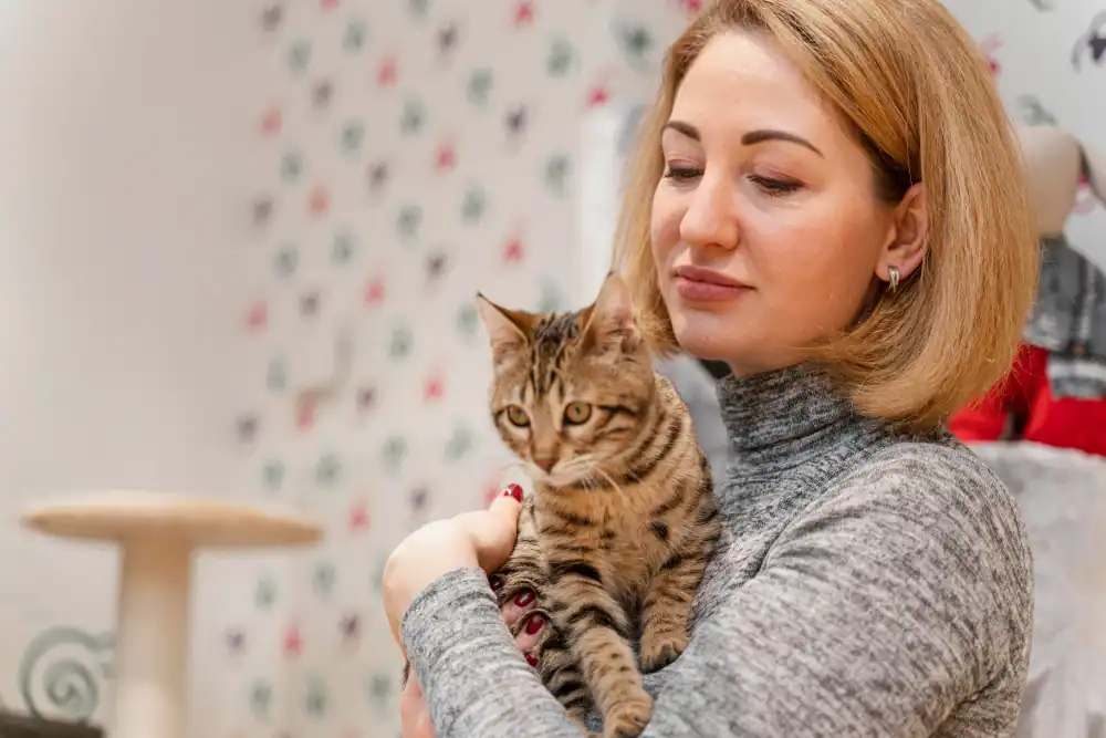 Frau hält Katze im Arm